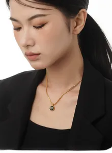 Elegante collana dorata con ciondolo circolare in pietra nera su una modella professionale