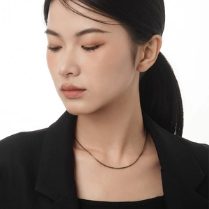 Minimalist S925 sterling silver golden twisted chain necklace worn by a model in a black suit