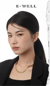 Close-up of a sleek 18K gold-plated herringbone snake chain on a female model