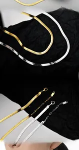 Macro detail of gold and silver S925 sterling silver flat snake chain necklaces with clasp