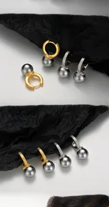 Detailed macro view of S925 silver hoop earrings with grey pearl drops and star engraving