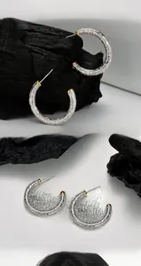 Détail macro de boucles d'oreilles C en argent S925 avec motif de vigne vintage