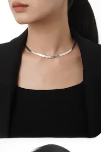 Detailed close-up of a minimalist S925 sterling silver flat snake chain worn by a model