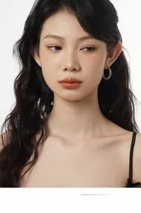 Gros plan de boucles d'oreilles en C argentées avec texture martelée et fini rétro