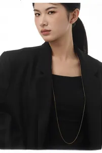 Minimalist gold snake chain necklace styled on a black blazer with elegant metal gloss