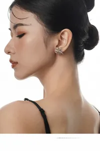 Gros plan de boucles d'oreilles étoiles à double couche en argent S925 portées par un mannequin