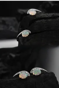 Macro detail of S925 sterling silver moon stud earrings with colorful oval opal stones