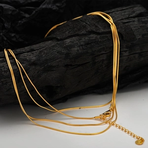 Three-layer gold snake chain necklace in S925 sterling silver for women on black wood