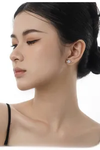 Close-up of S925 sterling silver moon stud earrings with colorful opal on a model's ear