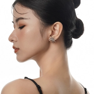 Boucles d'oreilles minimalistes en argent S925 double étoile portées sur une oreille