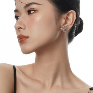 Boucles d'oreilles étoiles doubles en argent sterling S925 sur l'oreille d'un mannequin