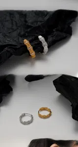 Detail of bamboo joint earrings in gold and silver finish with sparkling zircon stones
