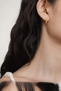 Close-up of gold bamboo-style S925 silver hoop earrings with sparkling crystal pavé