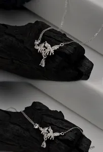 Macro shot of butterfly wing pendant with sparkling zircons on black charcoal base