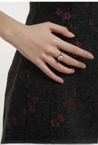Macro detail of a large champagne grey pearl ring with gold textured band and pavé crystals