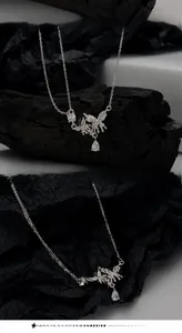 Macro shot of silver butterfly necklace featuring teardrop zircon and gothic wing details
