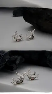 Détail macro de boucles d'oreilles papillon en argent S925 avec nacre noire