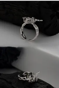 Détail macro d'une bague papillon en argent S925 avec incrustation de nacre et texture