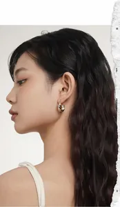 Detail of mixed-tone Möbius hoop earrings shown on a female model with high-polish finish