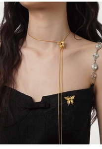 Detail van de onregelmatige textuur op de gouden S925 zilveren vlinderbroche en ketting