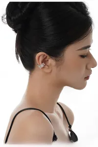 Close-up of a silver irregular moon-shaped ear cuff with agate inlay on model's ear