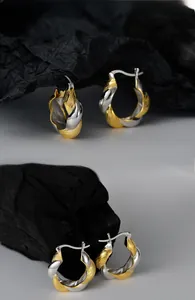 Detail of S925 sterling silver two-tone twisted Mobius hoop earrings with metal hallmark