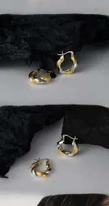 Close-up of S925 sterling silver Mobius earrings featuring two-tone gold and silver plating