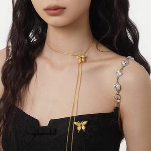 Elegant gold butterfly pendant necklace with crystal shoulder straps on black dress