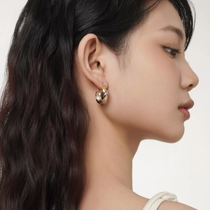 Two-tone Mobius knot hoop earrings in S925 sterling silver worn by a model