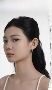 Close-up of polished S925 sterling silver liquid metal crescent earrings on a model