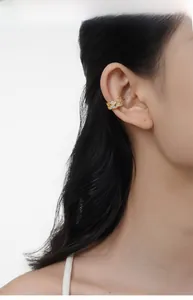 Close-up of minimalist gold-plated ear cuff with pavé-set sparkling cubic zirconia