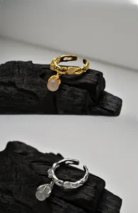 Details verstellbarer S925 Silberringe mit Lavastruktur und rosa Tropfenstein-Anhängern