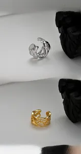 Detail of woven open rings in silver and gold plating with micro-pave zirconia crystals