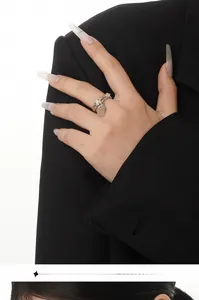Makroaufnahme eines silbernen Wassertropfen-Achat-Rings mit flüssigem Metalldesign am Finger
