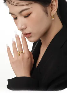 Detail von vergoldetem Ring mit Lavatextur und Tropfenohrring aus weißem Achat am Model