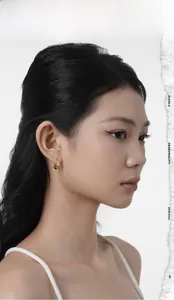 Close-up of a gold-plated hoop earring featuring sparkling star-shaped charms and fine crystals