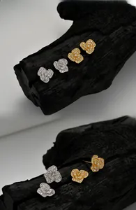 Vue détaillée de boucles d'oreilles fleurs en argent et or avec zircons étincelants