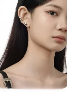 Gros plan du ear cuff serpent argenté avec zircons brillants sur l'oreille