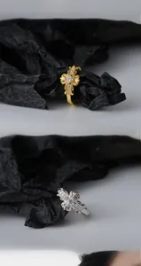 Detail of vintage cross rings in gold and silver finish on black textured background