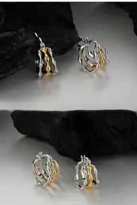 Detailed macro view of S925 sterling silver stamp on bicolor wavy geometric hoop earrings