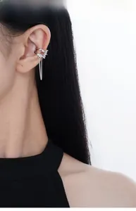 Silver cuff earring featuring geometric zircon studs and long tassel chain on ear