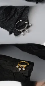 Dettaglio di orecchini a clip in argento S925 con zirconi e ciondoli pendenti