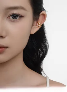 Dettaglio di un ear cuff dorato in argento S925 con pendenti in zircone scintillante