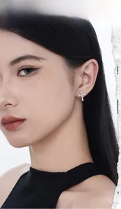 Close-up of S925 sterling silver cross stud earring with zircon inlay on model ear