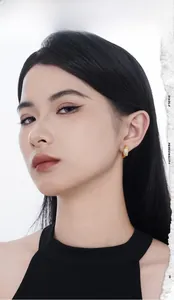 Close-up of elegant gold-plated hoop earrings with micro-pave crystals on a female model