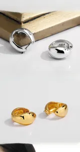 Detailed view of polished S925 sterling silver hoop earrings with engraved hallmark