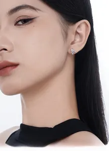 Gros plan de boucles d'oreilles étoiles en argent S925 avec zircon portées par une femme