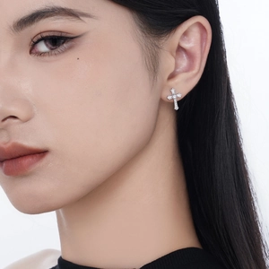 Sparkling S925 sterling silver cross stud earrings with cubic zirconia on female model