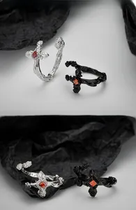 Close-up of S925 sterling silver gothic cross ring with red zircon and rose texture