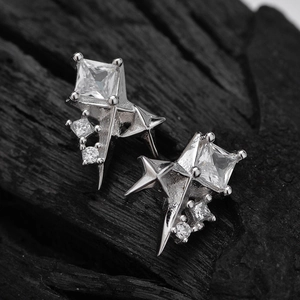 Boucles d'oreilles étoiles en argent S925 avec zircon carré sur fond bois sombre